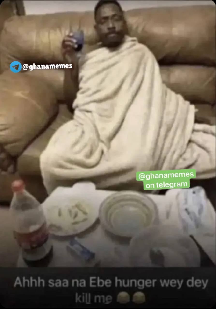a man wrapped in a blanket is seen on the couch